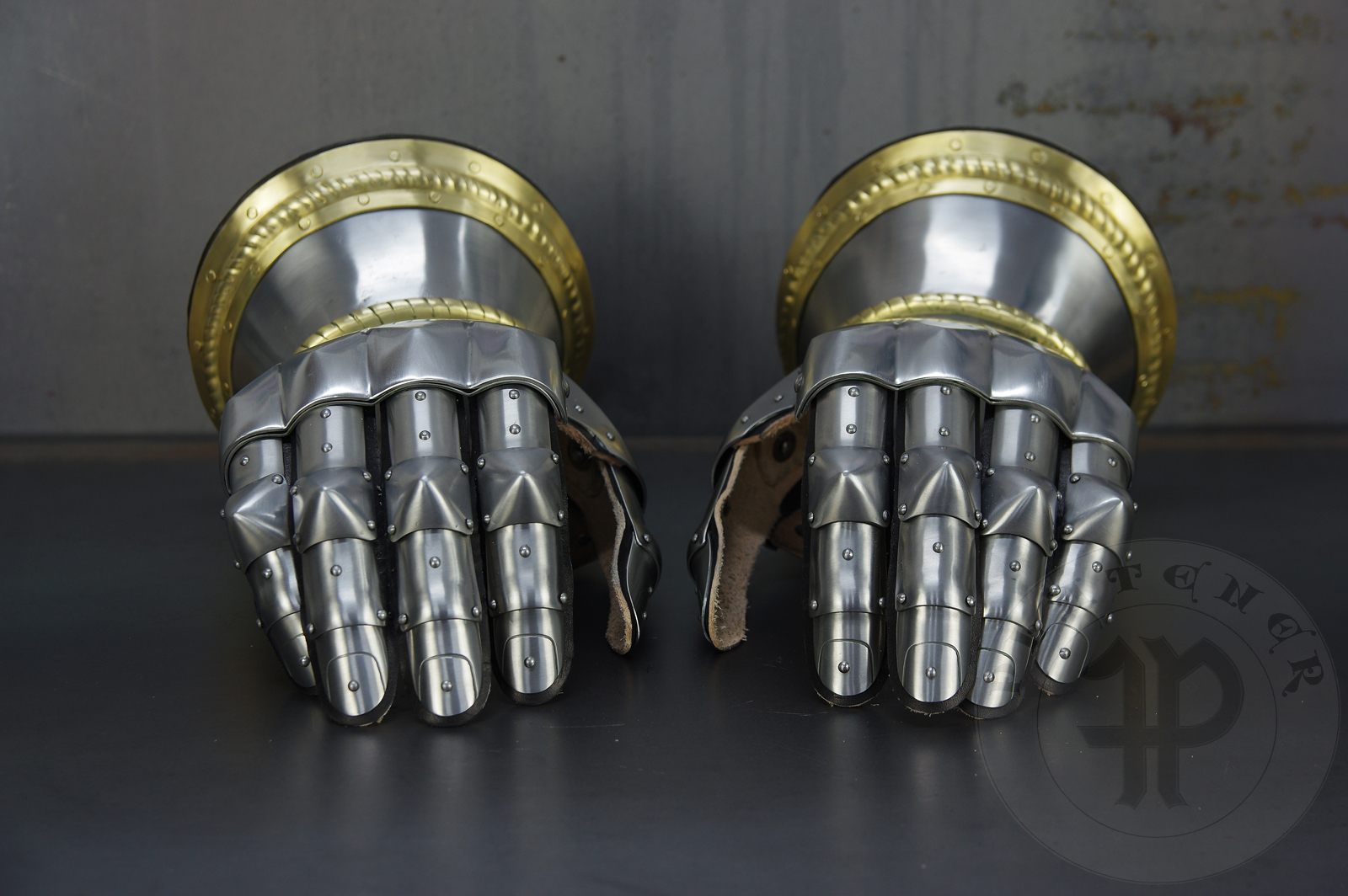 Hourglass gauntlets forged without welding from medium carbon steel, heat hardened and tempered up to 42 HRC. Fingers in articulated construction inspired by finds from Sweden. Brass decoration with roping motive./Rkawice klepsydrowe wykonane bez spawania ze stali redniowglowej, hartowane i odpusczane do 42 HRC. Palce w konstrukcji segmentowej wzorowane na znaleziskach ze Szwecji. Mosine dekoracje z motywem linowym.